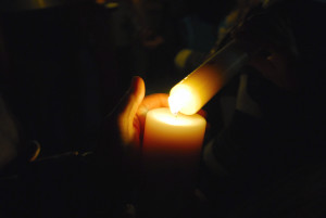 Parishioners light their candles from the holy fire during Holy Saturday services at St. Bernard Church on Saturday, March 30, 2013.